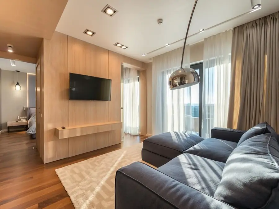 Modern condominium living room with wood paneling and floor-to-ceiling windows